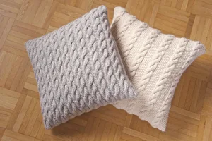 Dekorative Kissen mit Zopfmuster selber stricken. (Foto: Avesani Verlag)