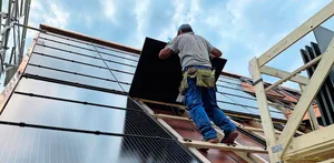 Montage von PV-Modulen für eine Indachanlage auf einem Neubau. Solche Systeme sind zwar teurer als Aufdachanlagen, dafür können die Ziegel eingespart werden.