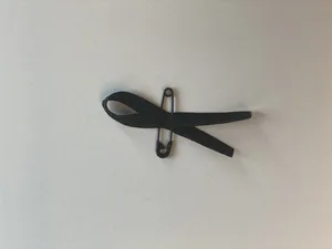 Eine Trauerschleife zu tragen, kann ein Symbol sein: Ein Zeichen dafür, dass Sie an eine verstorbene Person und an die Hinterbliebenen denken.