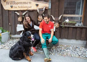 Ruhige Momente auf der Bank vor der Event-Scheune sind bei Caroline Wyss und Domenik Ledergerber rar – auch Hofhund Maiko will dabei sein. Bild: Gian Vaitl