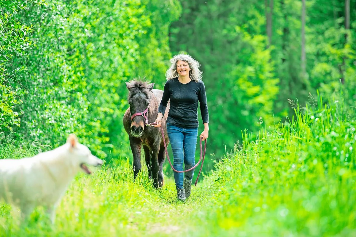 ceaca751adeacad995cb03d4e87a627dc077fd2202b849a64ba479d0beae7da1 Neben einer der Hecken, die zum Betrieb gehören, spaziert Corinne Kählin mit ihrer alten Stute Dögg. Im Vordergrund die Hündin Dis, eine der sieben Hunde, die auf dem Hof alt werden dürfen.