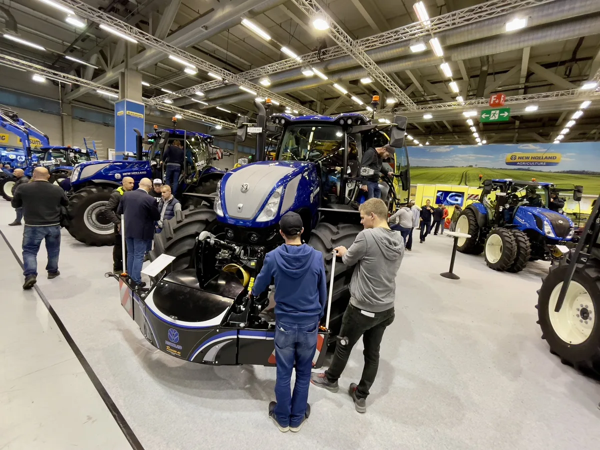 Agrama-Besucher vor einem New Holland-Traktor.