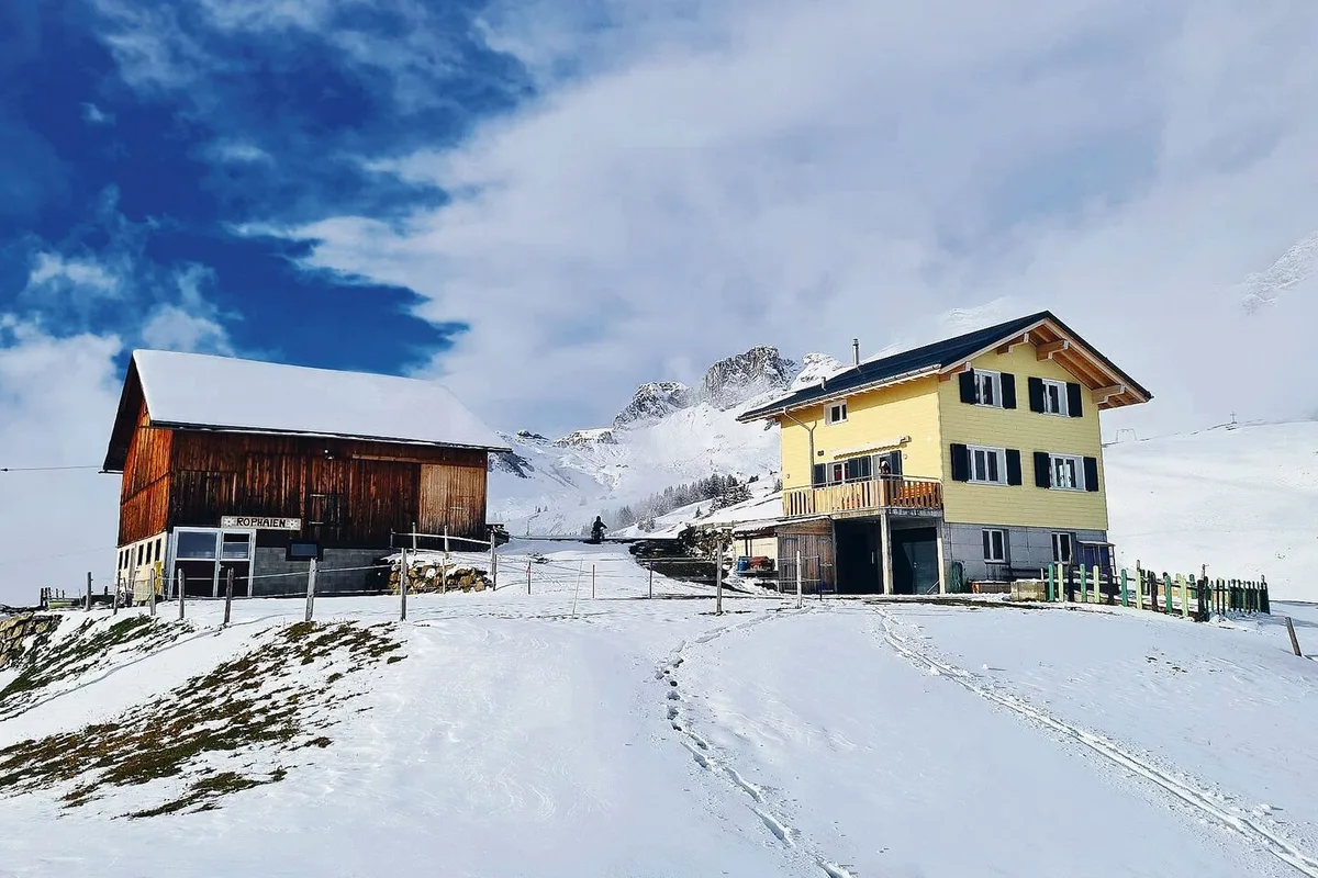e9b229e70240f001386e9349177ae015e53857525b00d604370f85e5efbf191c Das neue Wohnhaus und der mit viel Eigenarbeit sanierte Rinderstall der Familie Arnold auf dem Bergbetrieb Rophaien.