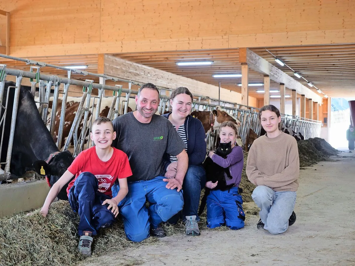 b13fefb08af4f012a47e9b3af9f52a7e350fe21660c692358ad092a5169373e0 Michael und Katrin Stalder mit ihren Kindern Manuel, Salome und Lena (v.r.n.l.) im neu gebauten Laufstall. Dank der neuen Technik wie Melk- und Mistroboter bleibt nun mehr Zeit für die Familie.