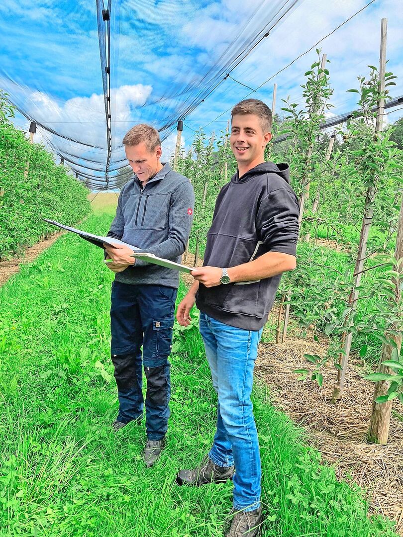 Damian Gut (rechts) in seiner Obstplantage bei der Prüfungsabnahme durch Thomas Renggli.