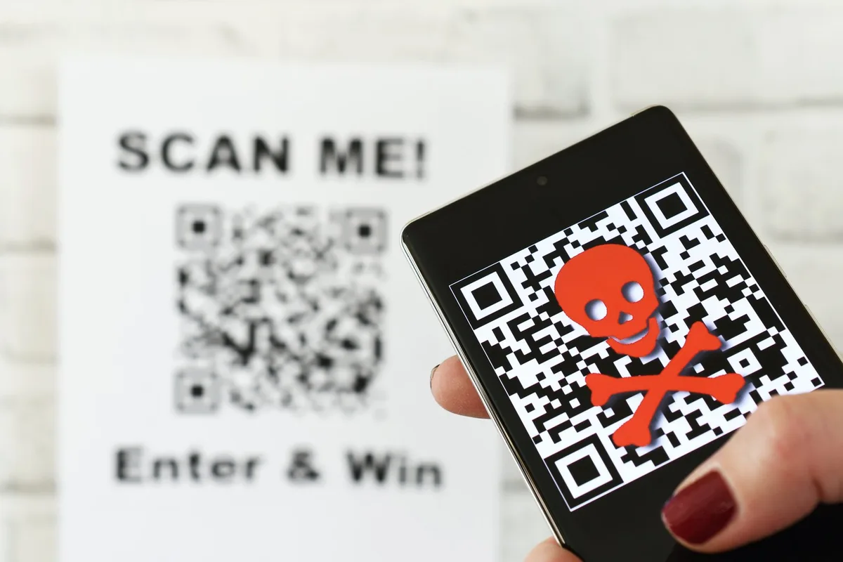 BZ-LAN2-49-QR-jgl QR code scam concept - scanning a fraudulent QR code can lead to phishing websites or malware apps.