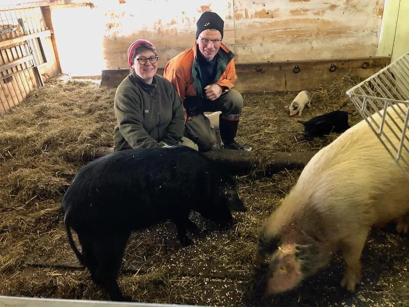 366b996f71f7f360e50ebdd22ba817311ab95919 Susanne und Christian Knaus mit ihren Alpenschweinen: Bei der Muttersau vorne rechts stimmt zwar die Blutlinie, sie muss trotzdem ausgemerzt werden, da sie zu wenig schwarze Ferkel wirft. (Bilder Esther Thalmann)