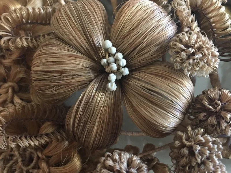 a4ecf0a5a2ada23f7a4127e4da9e26d0a66deb89 Detail einer Haararbeit aus dem 19. Jahrhundert. Um Haare zu Blüten und Blumen zu formen, brauchte es eine ruhige Hand. (Bild Tal Museum)