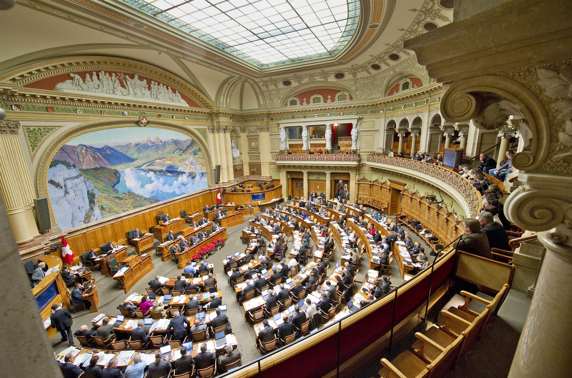 Der Nationalrats-Saal mit dem Wandbild, auf dem die Rütliwiese und im Hintergrund die beiden Mythen zu sehen sind.