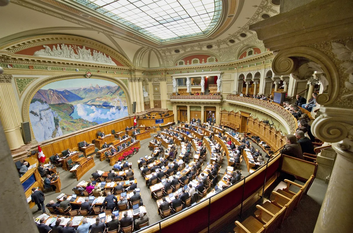 nationalrat_01_parlamentsdienste-3003-bern Der Nationalrats-Saal mit dem Wandbild, auf dem die Rütliwiese und im Hintergrund die beiden Mythen zu sehen sind.