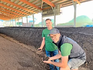 Geschäftsführer Klaus Seiler (l.) und Betriebsleiter Tobias von Rotz begutachten die Qualität des Kompostes in den grossen Hallen der Naturaenergie AG in Kägiswil. Im Hintergrund die Lagerbehälter mit dem Biogas.