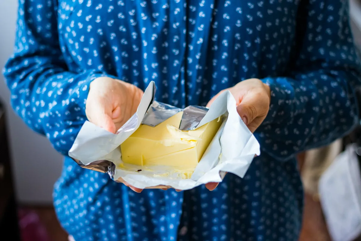 schweizerdeutsch-butter-adobestock Butter-Mödeli in den Händen einer Bäuerin.