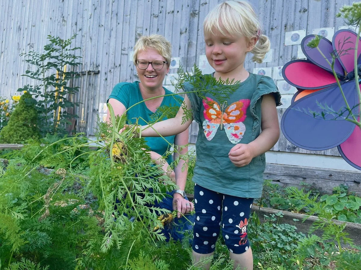 acf6fcb43415b32cd16e81facf9b063d1c01257be98c9e28eefabc889070a7dd Yvonne Lustenberger mit Tochter Leonie im Garten der Spielgruppe. Hier lernen die Kinder etwa, dass Rüebli nicht «gruusig» sind, nur weil bei der Ernte noch Erde daran klebt.