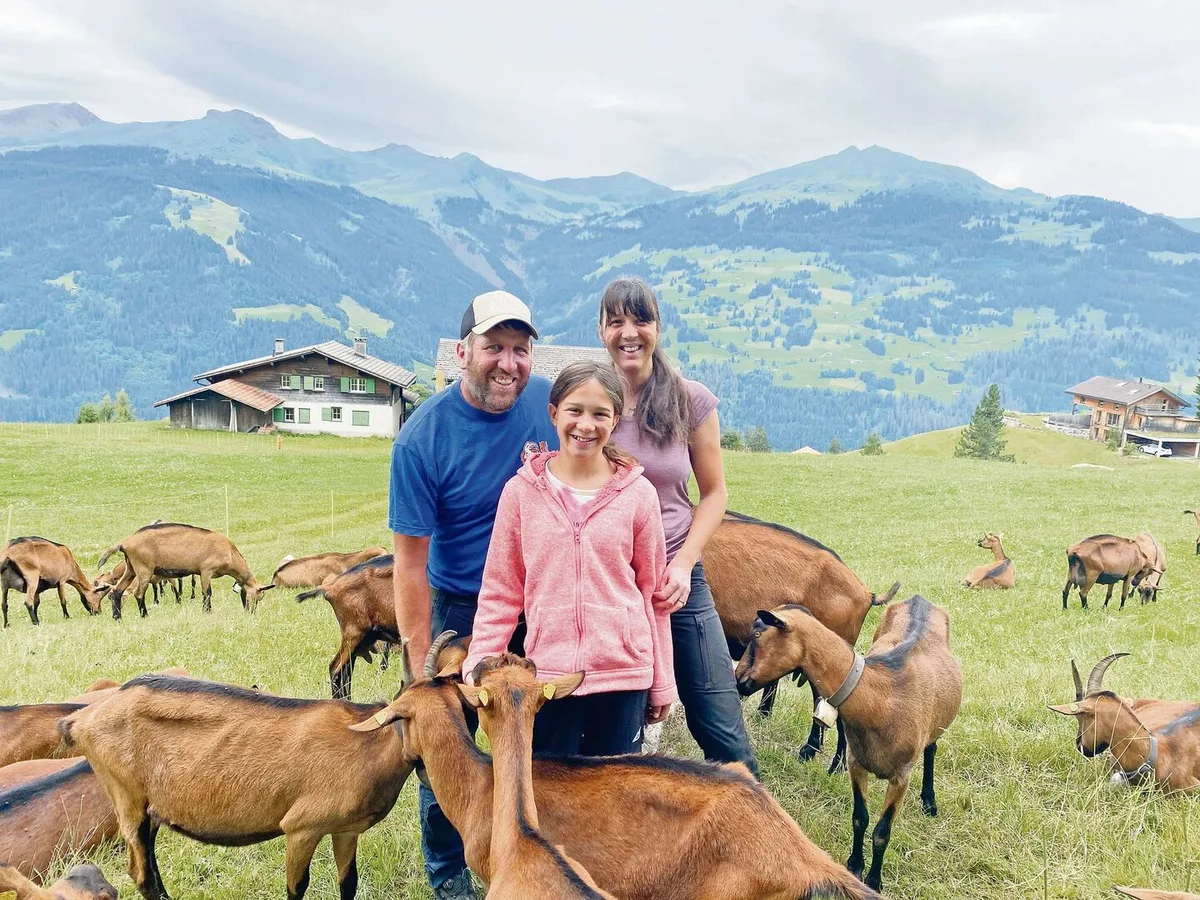 Ladina Lötscher mit Ehemann Abraham Lötscher und der jüngsten Tochter Svenja auf der Geissenweide. Die Herde besteht vorwiegend aus Tieren der Rasse Gemsfarbige Gebirgsziege. Sie werden von Dezember bis Oktober gemolken.