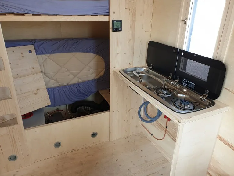 9031e33e0940ea7ab8b92fd4357fce157a6fb4f3 Kajütenbett und Kochecke. Die Hütte enthält Elemente aus dem Camping-Bereich. (Bild lid)