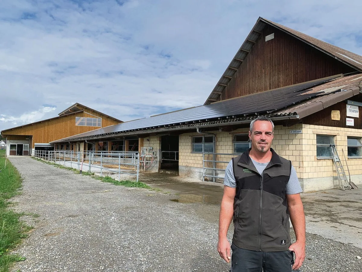 0619a43f2f9bd852f3866e6a50243e2eb7dc4f2addd144227da24ca96ae43012 Stefan Troxler vor der 2013 erstellten Solaranlage auf dem Scheunendach. Diese wurde 2021 auf eine Leistung von 130 kWp erweitert. Der meiste Solarstrom muss ins Netz abgegeben werden.