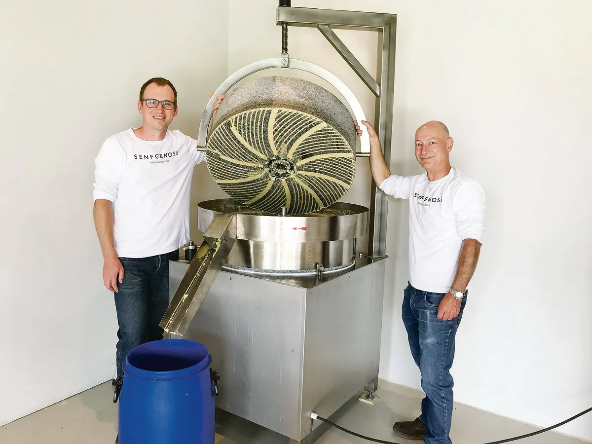47b24a8bdb70a99fc57af88ab52288301319d333 Ueli Kilchsperger (links) und Beat Voegeli zeigen die Steinmühle mit den 300 Kilogramm schweren Granitscheiben, zwischen denen die Maische zu Senf vermahlen wird.(Bilder Alexandra Stückelberger)