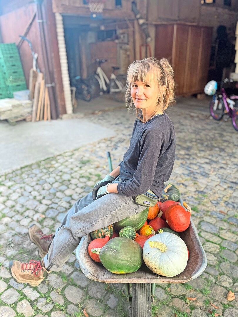 Ernteglück: Sarah Elser auf einer Karette voller Kürbisse.