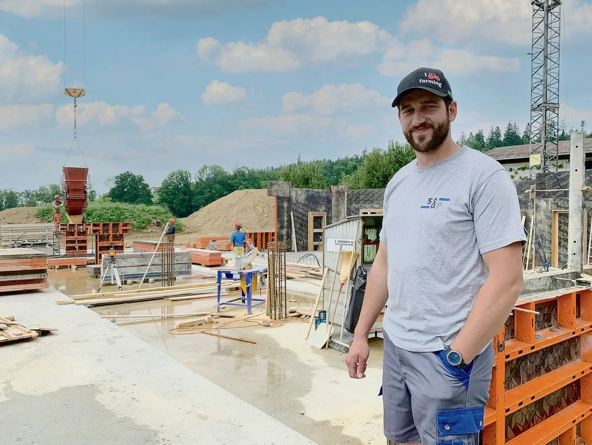 ef5cf7537e78c451e87f99096bef2a08f663791e22d874d8c2dd33f9ff9075a2 Bauherr Christian Grüter vor der Baustelle mit dem Fundament für den Milchvieh-Laufstall. Bald wird aufgerichtet. Die höheren Preise für Stahl und Beton spürte er.