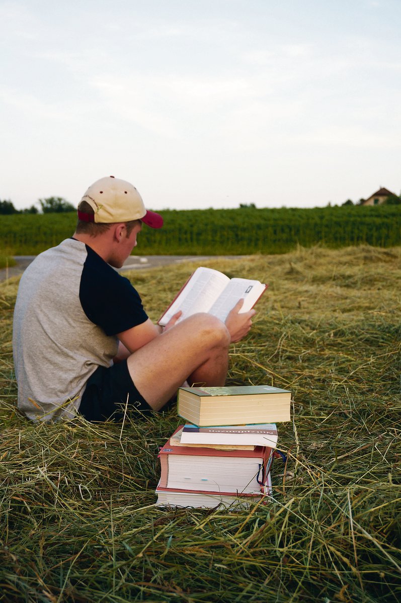 Der Bücherstapel auf dem Acker sieht etwas befremdlich aus. Das täuscht: Praxis und Theorie beissen sich nicht, sie ergänzen sich wunderbar.(Bild Deborah Rentsch)