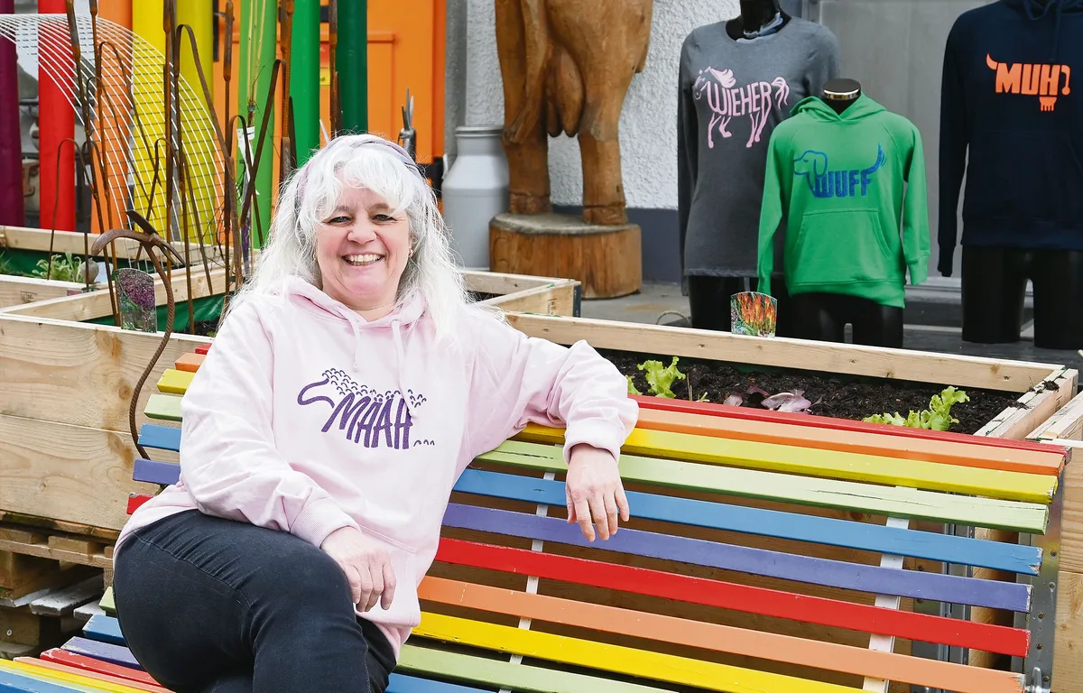 06f1672df3860129cd8f80b3dc49c90bad825816 Francine Riesen sitzt mit einem ihrer selbstbedruckten Pullover vor ihrem Laden in Burgistein BE. Diesen kann man wegen seiner farbenfrohen Präsentation fast nicht verfehlen.(Bild Jasmine Baumann)