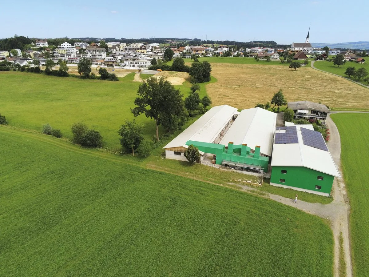 7d87ba9e93c48b544a0262cb15336a185e5df4bb Das Dorf Rain LU wächst immer weiter in Richtung Schweinestall der Familie Bucheli. Dank dem Bioluftwäscher (an der Stirnseite des mittleren Gebäudes) stinkt es nicht. Bild: die grüne/Martina Rüegger