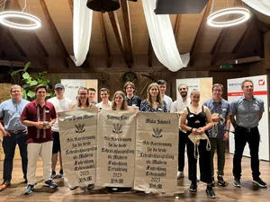 Die Abschlussklasse 2023 begleitet von den Prüfungs-Chefexperten Beat Halter (links aussen) und Roman Hersche (rechts aussen).