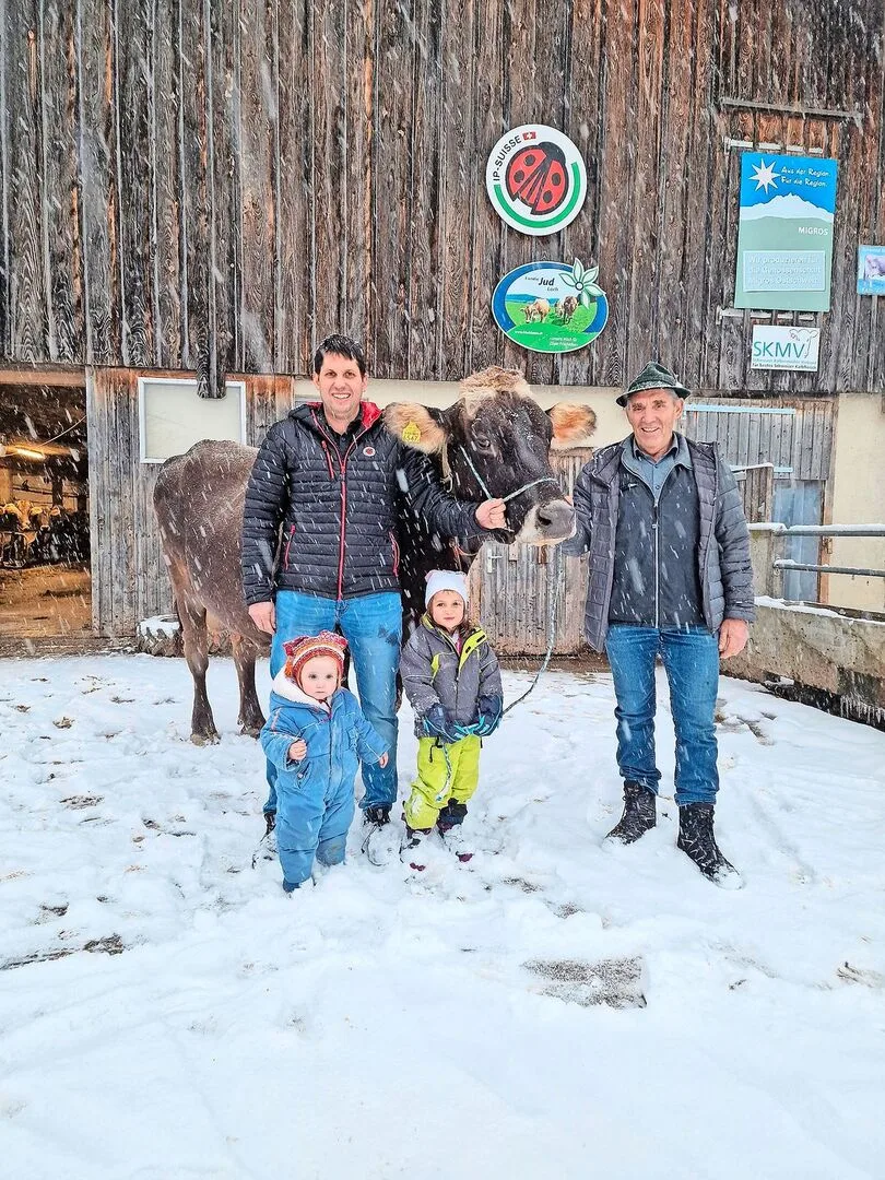 Drei Generationen und eine Ausnahmekuh: Mathias Jud mit den Töchtern Mara (l.) und Lea und sein Vater Wendelin. Die Braunviehkuh Ursi hat bereits über 127 000 kg Milch geleistet.