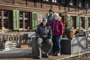 Vater Manfred (sitzend) und Sohn Hannes Kunz mit Barbara Kunz vor dem Bauernhaus in Ersigen BE.