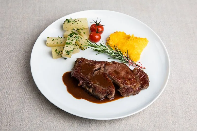 806aa7cc31af3ac5e8636f5b8f67ddef1da9b981 Hohrückensteak an Balsamicosauce mit Polentaschnitte und Kohlrabi. (Bild SRF/ Ueli Christoffel)