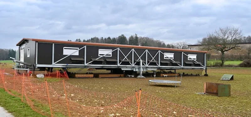 3c414c73989fb84a77dafcd17321e378fe0d61c9 Der fahrbare Legehennenstall für 2000 Hühner ist rund 30 Meter lang und steht im Feld auf sechs Stützen, die zum Transport hochgefahren werden können. Der Raum unter dem Wagen wird hier als zusätzlicher Wintergarten genutzt. (Bilder Jasmine Baumann)
