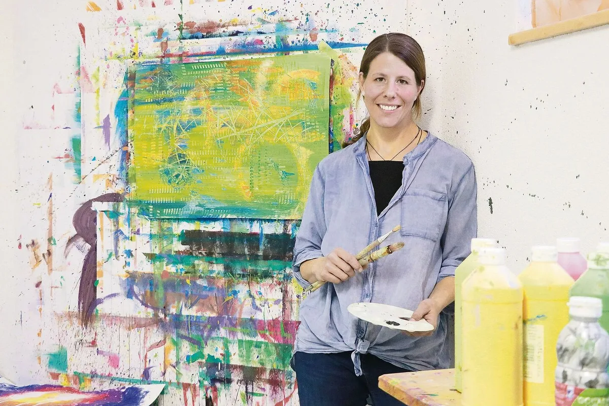 f5cedcfcf6b039d52b88113dad3ed9e0a5b6c0af53378fb1f4e7286a499def27 Karin Blunschi in ihrem Atelier. Im Hintergrund ist ein «Restenbild». Übrig gebliebene Farbe wird nicht den Abfluss runter gespült, sondern zu einem letzten Bild aufs Papier gebracht.