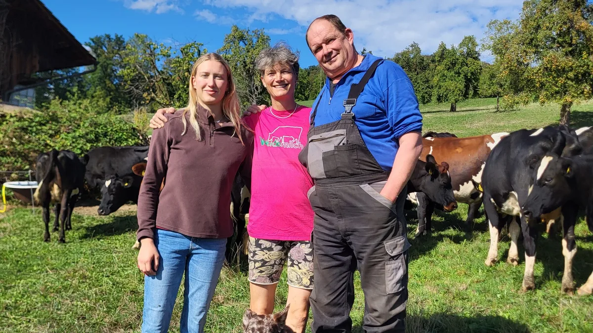 Familie Gyr.jpeg Selina, Helen und Christian Gyr mit der Hündin Leila vor ihrer Weidemilch-Kuhherde. Leila hilft als Treibhund beim Umtrieb der Kühe von einer Weide zur anderen.