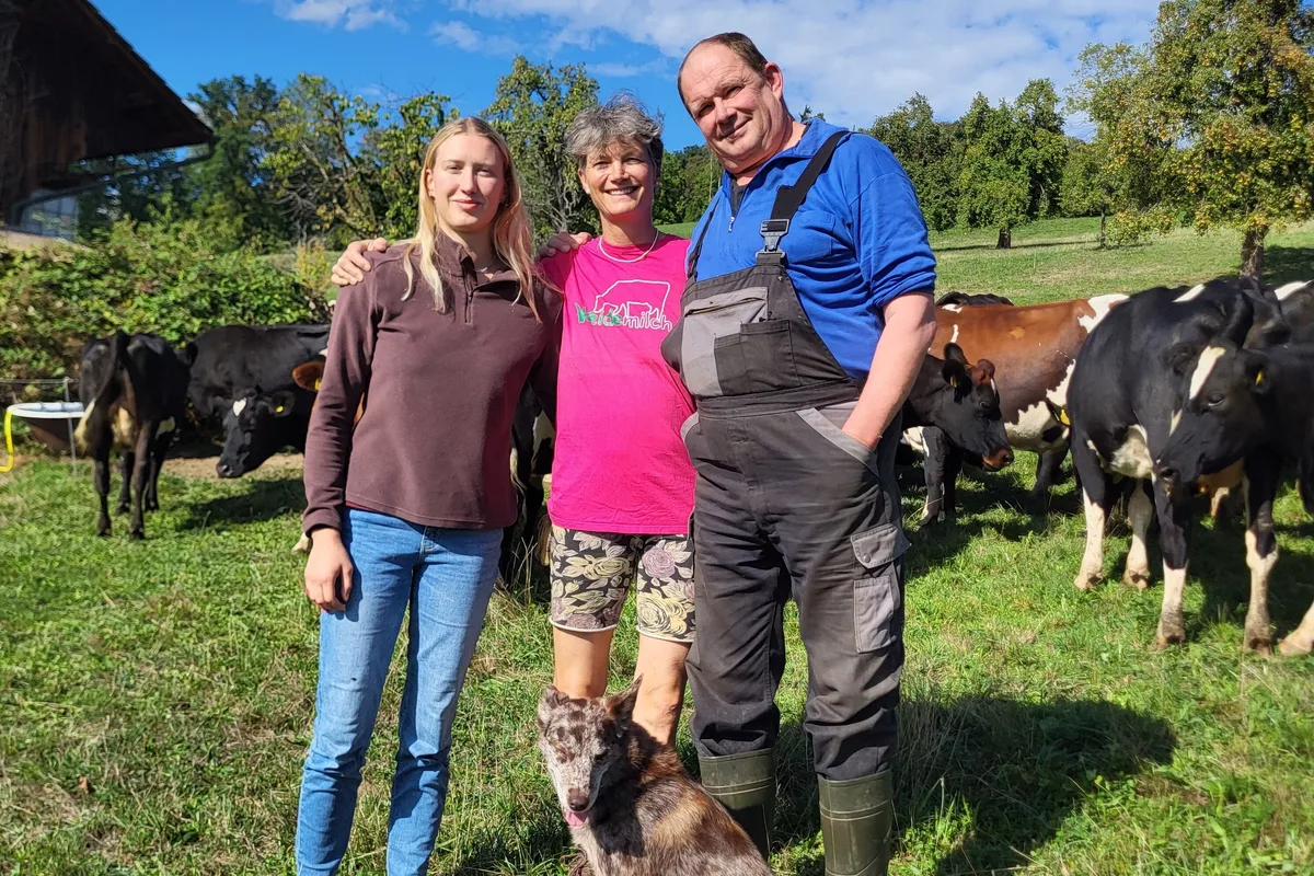 Familie Gyr.jpeg Selina, Helen und Christian Gyr mit der Hündin Leila vor ihrer Weidemilch-Kuhherde. Leila hilft als Treibhund beim Umtrieb der Kühe von einer Weide zur anderen.
