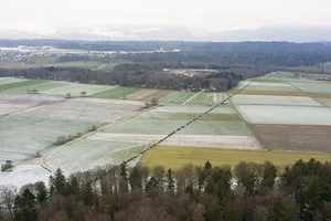 Eine lange Kolonne aus Traktoren steht dort, wo nach den Plänen der Behörden einmal eine Strasse verlaufen soll.