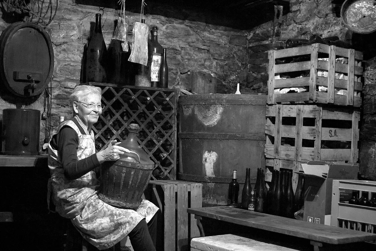 6c13f4eb14c0098f127b4454b1f0abc77f290118e397d01d14e80b0edc796cdd Marie in ihrem Keller in Visperterminen, mit dem 28-jährigen Schnaps, den ich unbedingt probieren will.