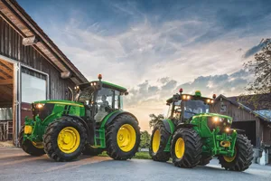 Zwei John Deere-Traktoren im Gegenlicht.