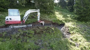 Mit dem Bagger hat Paul Bellmont die Quelle oberhalb der Alp Äbnenmatt vorsondiert. Er überlegt noch, ob er einen Meter weiter graben soll, bevor er schliesslich das Wasser mit einem Rohr fassen und in die Tränke ableiten wird.