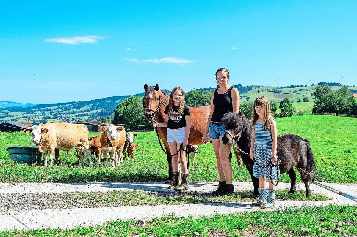 830632835f7a3ab67c344dd83c4c4ab6c076e92625f29b9f7f0da09aec94175f Larissa mit ihrem Pony Dino, Martina Wicki und Lea mit dem Shetty Leni. Die betriebseigenen Simmentaler-Mutterkühe mit ihren Kälbern beobachten die Szene.