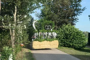Die Nachbarn bringen die Buchsbaumdekoration für die Hofauffahrt zum Polterabend.