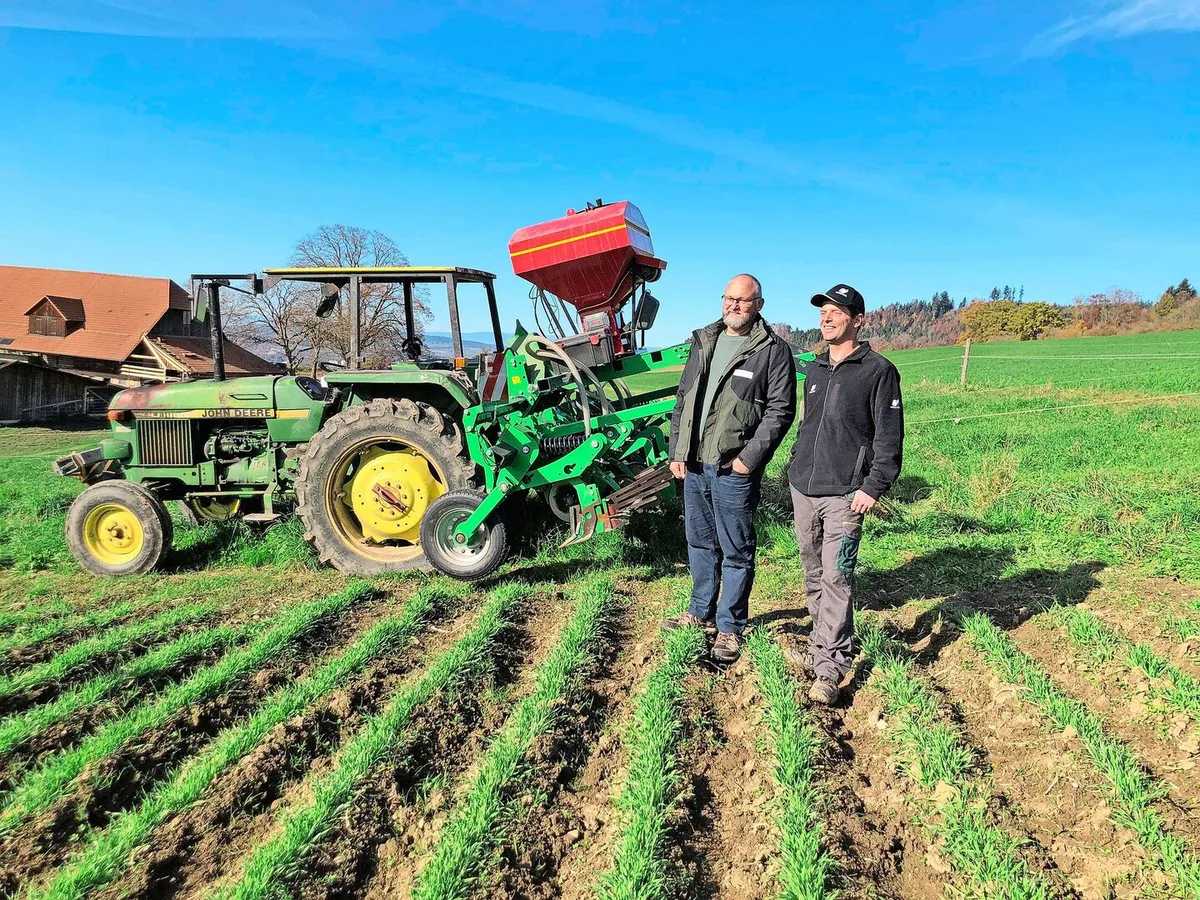 22d6b5078a7abf690760c6077f56a845488c6219d0482ba4ea352d55ffb88b7d Stefan Rohrbach und Michael Kipfer vor der Damm-Maschine im Braugerste-Feld. Der Einsatz der Maschine ist auch mit leichten Traktoren und in Hanglagen möglich.