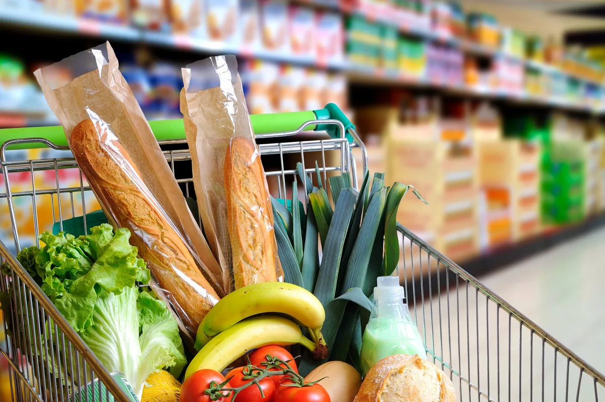 Fotolia_97901962_XL Shopping cart full of food in supermarket aisle elevated view