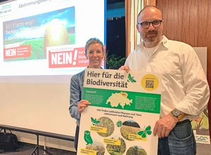 Thomas Rickenbacher und Sandra Helfenstein präsentieren das Plakat, das auf Höfen auf die vielen bereits bestehenden Biodiversitäts-Förderflächen hinweisen soll.