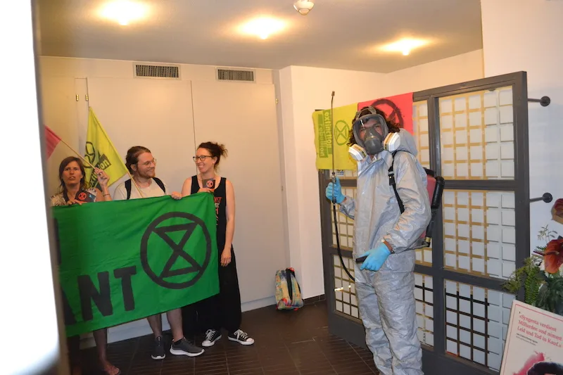 700499dd96f03156e0596114082ba03c3aed6275 In voller Schutzmontur empfing ein Aktivist der "Extinction Rebellion" die Teilnehmenden der Podiumsdiskussion am Ausgang. (Bild jsc)