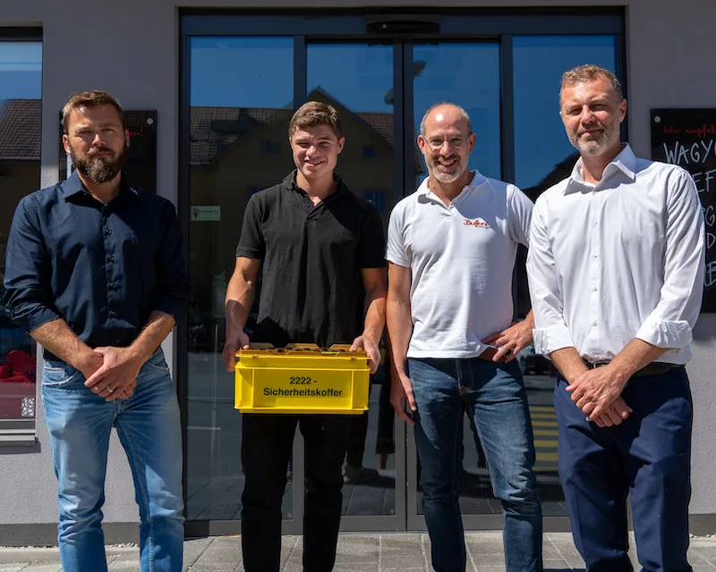 Daniel Speck, ABZ Spiez; Tön Staubli und Enrico Buffoni, Metzgerei Buffoni, Illnau; Daniel Stuber, Safe at Work bei der Übergabe des 2'222ten Sicherheitskoffer. (Bild EKAS)