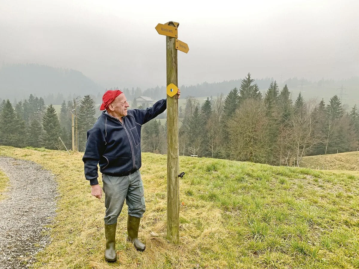 Willi Trüb von der Haselegg, Entlebuch, zeigt auf die Richtungsschilder für den Wanderweg Richtung Schwarzenberg. Nicht wenige Wandernde würden die aber nicht beachten und auf dem Schotterweg links weiterlaufen.