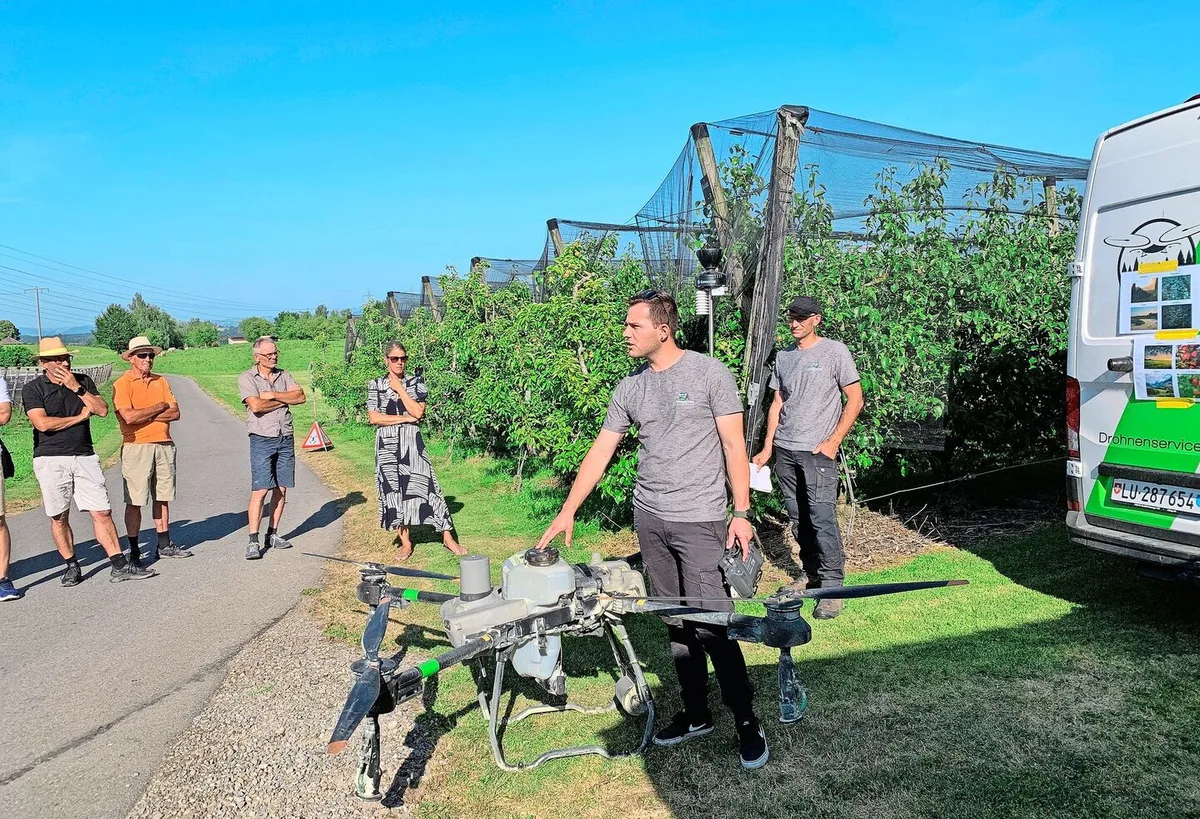 Philipp Schmidli und Martin Niederberger (r.) von den Agrarpiloten Zentralschweiz präsentieren den Weinbauern auf dem Betrieb vom Südhang in Eschenbach den Einsatz der Drohne für den Pflanzenschutz im Rebbau.