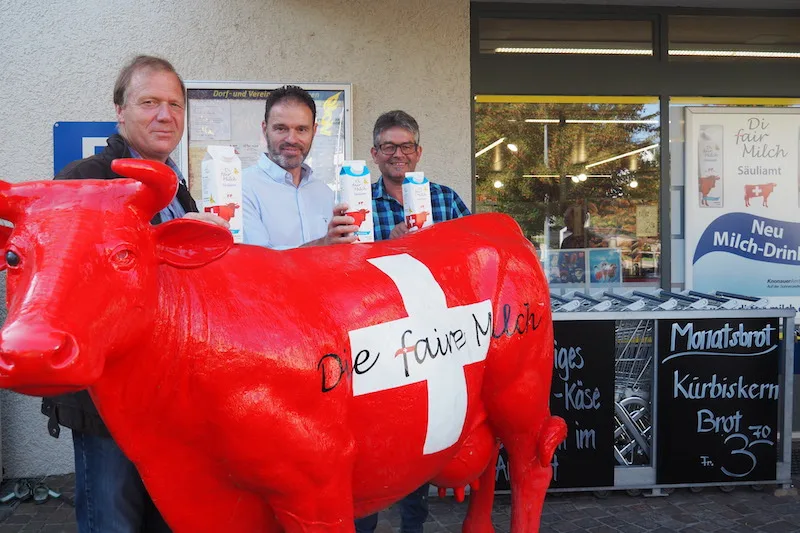 86b09c0413c5ad472b9c6541554e1dfa8a2e2caf Werner Locher, der Präsident des Vereins Faire Milch (links) und Medienverantwortlicher Martin Haab umrahmen Armin Heller, den Geschäftsführer der Landi Albis. (Bild chw)