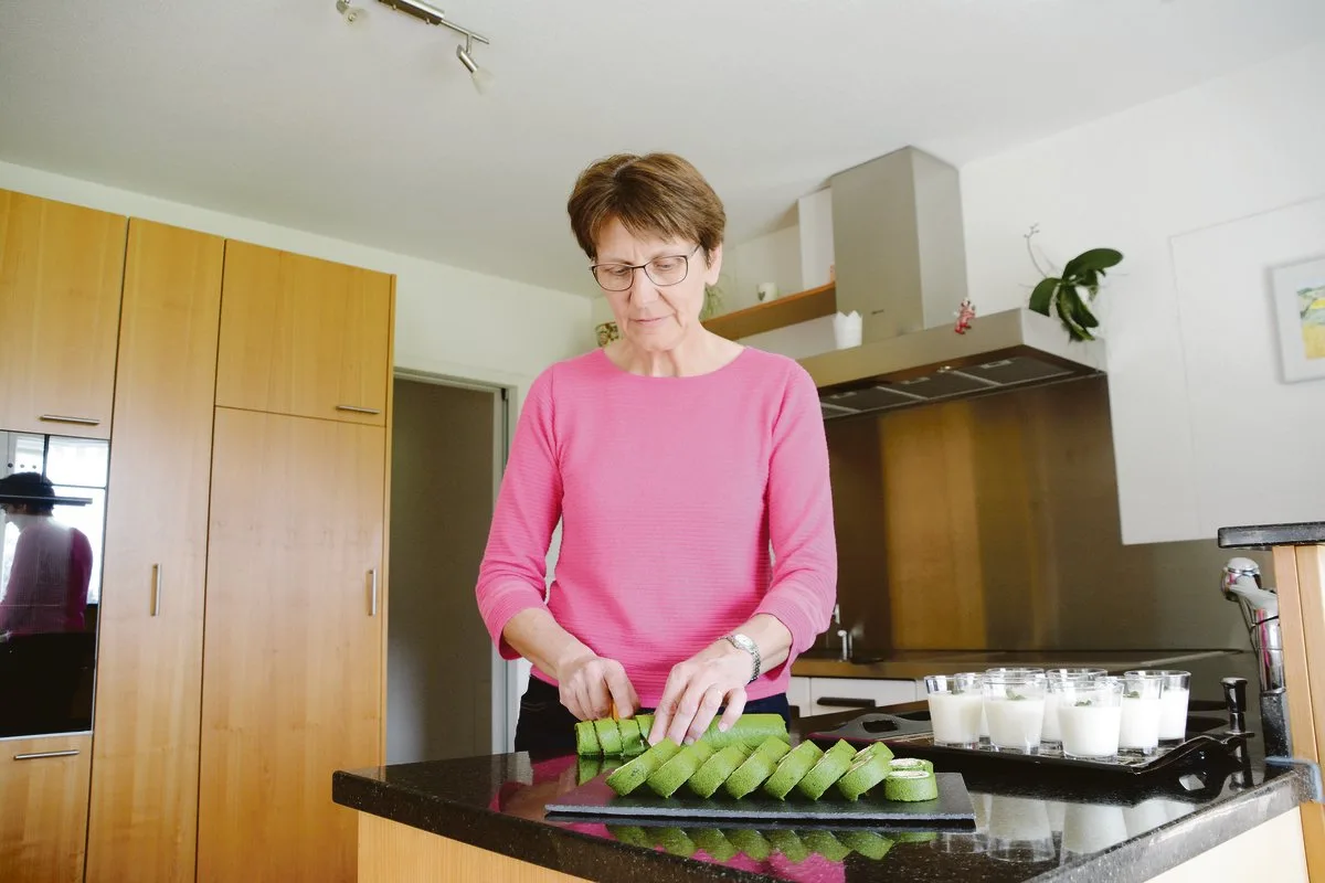 55a799d017d96c22837de1f0322b9e0892b7225a Ruth Stalder hat Spinatrouladen mit Frischkäse und Sbrinz sowie eine Holunderblütencreme zubereitet. Bevor sie die Gerichte ins Lager nach Neuenkirch bringt, schneidet sie die Rouladen bereits fixfertig auf.(Bild Andrea Gysin)