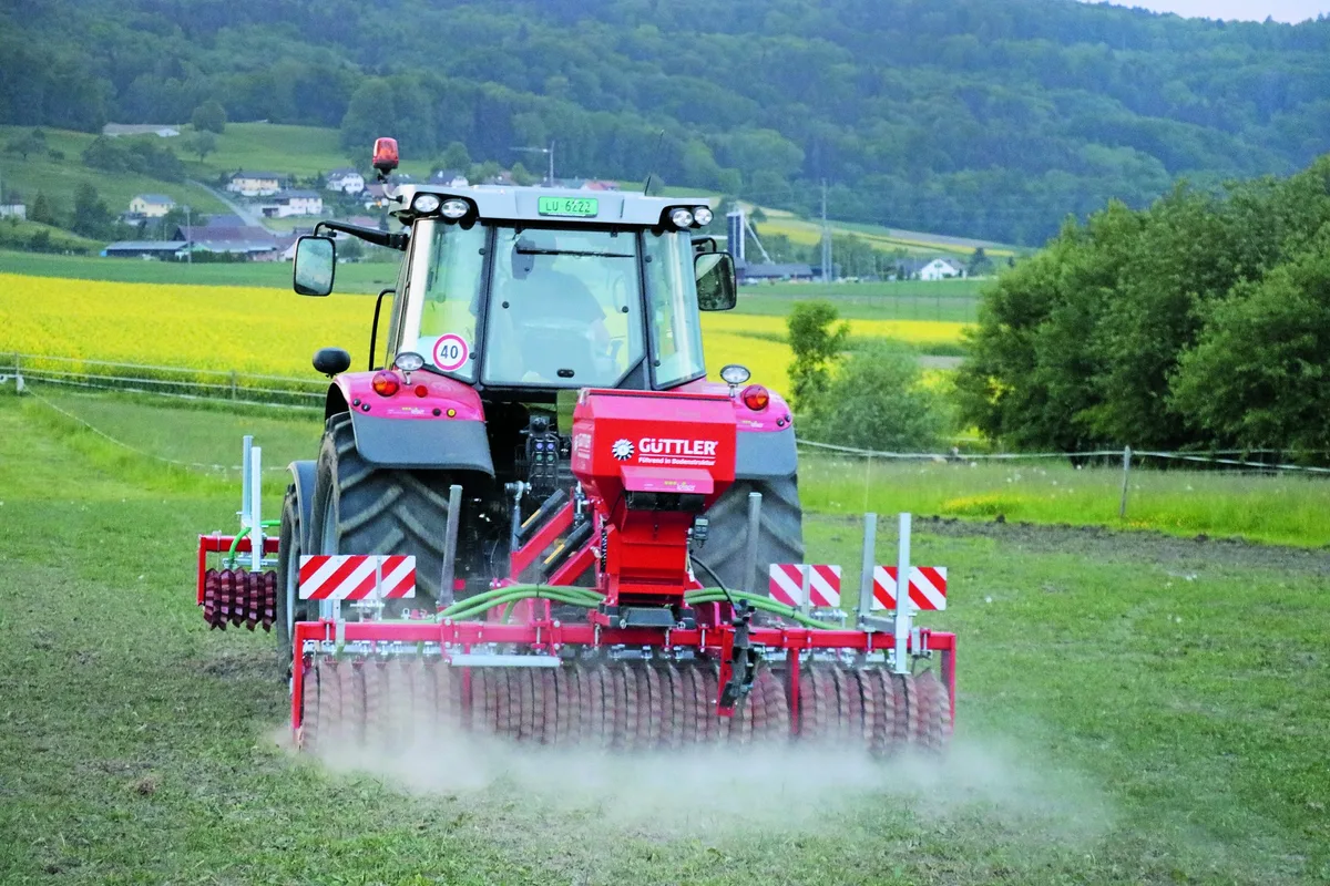 dg_22-03_pb1_aufmacher_neuuebersaat_pferdeweide_1 Traktor mit angehängter Sämaschine macht eine Übersaat auf einer Naturweide.